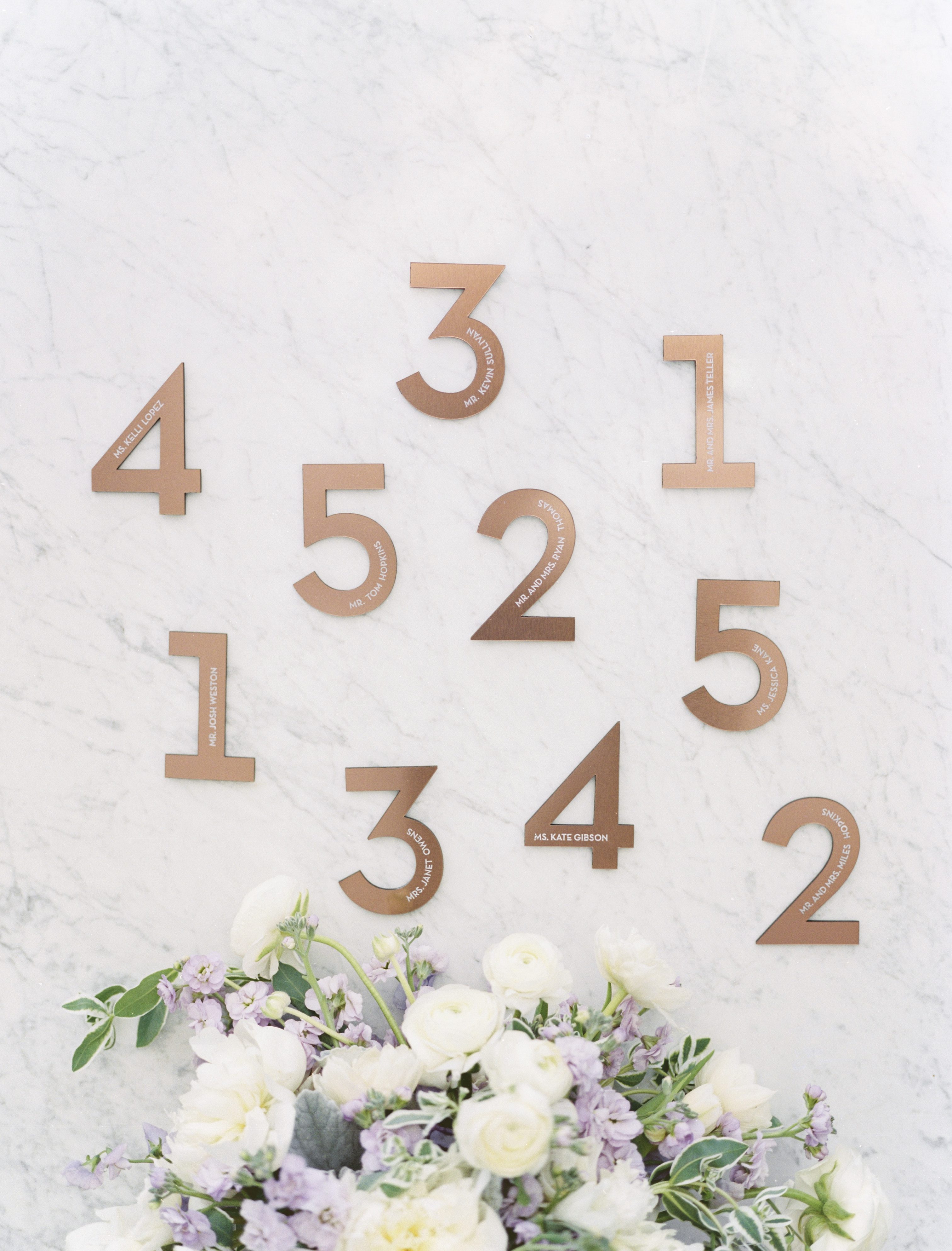 copper and marble escort card wall at a lavender and copper wedding