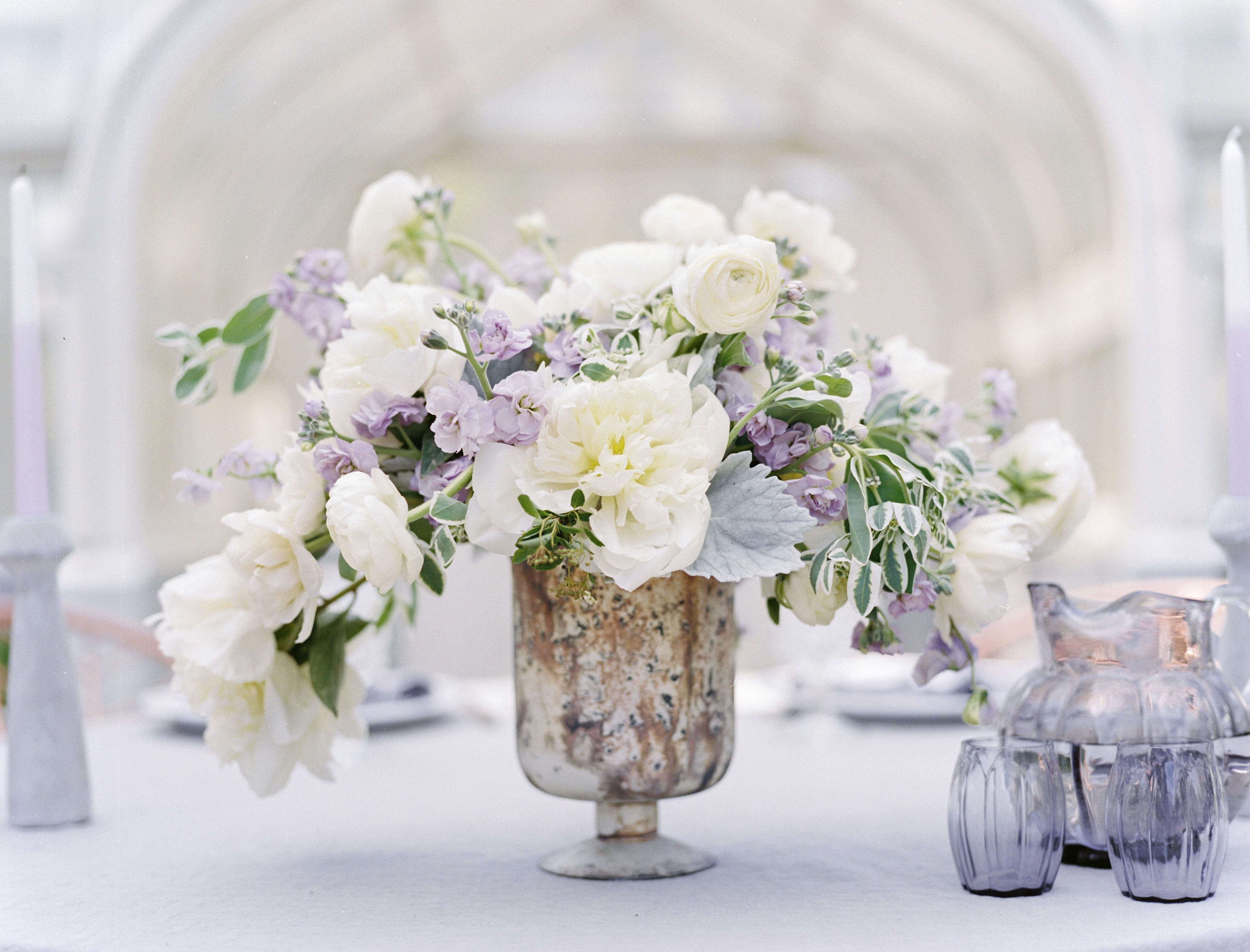 white and lavender centerpiece in a marble vase at a lavender and copper wedding