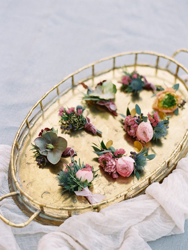 Hellebore boutonnieres with pink ranunculas styled on tray at a Dallas outdoor elopement