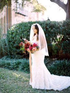 bride holding pink and burgundy bouquet