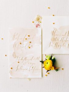 hand written wedding invitation with a yellow boutonniere