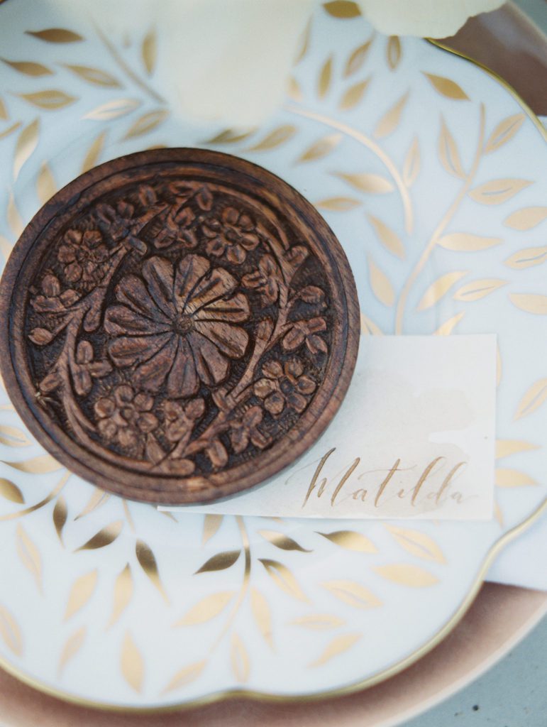 ornate wooden coaster and place card at a los angeles wedding