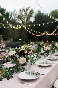 Long wedding tables under string lights at wedding