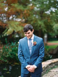 Groom in a blue suit with mauve boutonniere