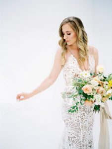 Made With Love Sasha wedding dress worn by Charla Storey Photography for her own bridal portraits featuring a peach and yellow bouquet. Wedding planned and designed by Birds of a Feather Events