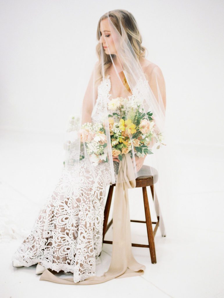 Made With Love Sasha wedding dress worn by Charla Storey Photography for her own bridal portraits featuring a peach and yellow bouquet. Wedding planned and designed by Birds of a Feather Events